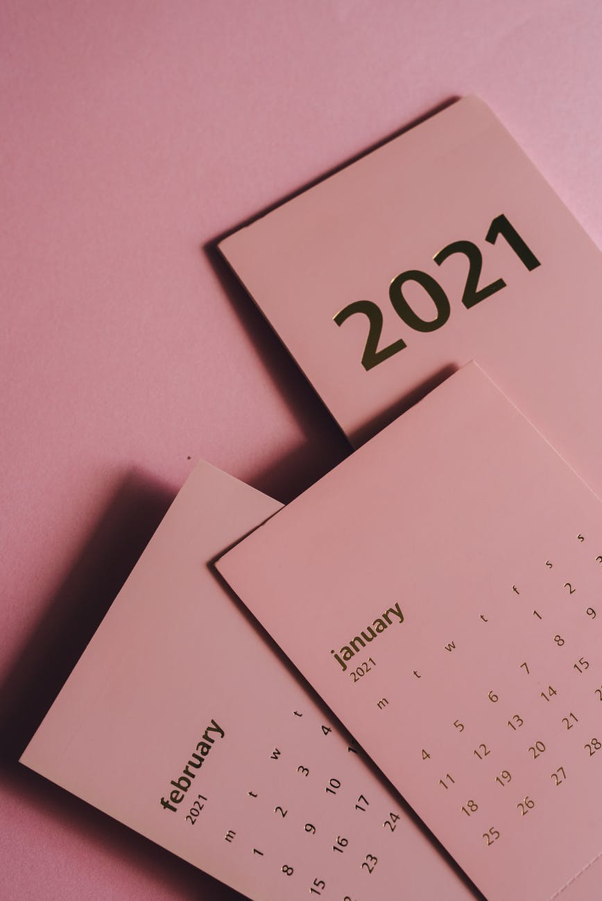 set of paper calendars with months on pink background